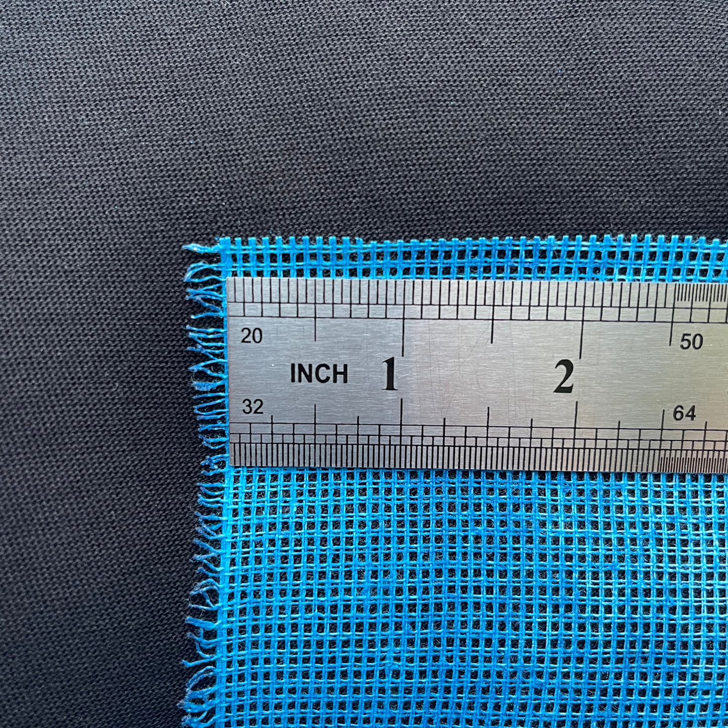 Blue 12ct waste canvas with ruler showing grid size and stitch count spacing