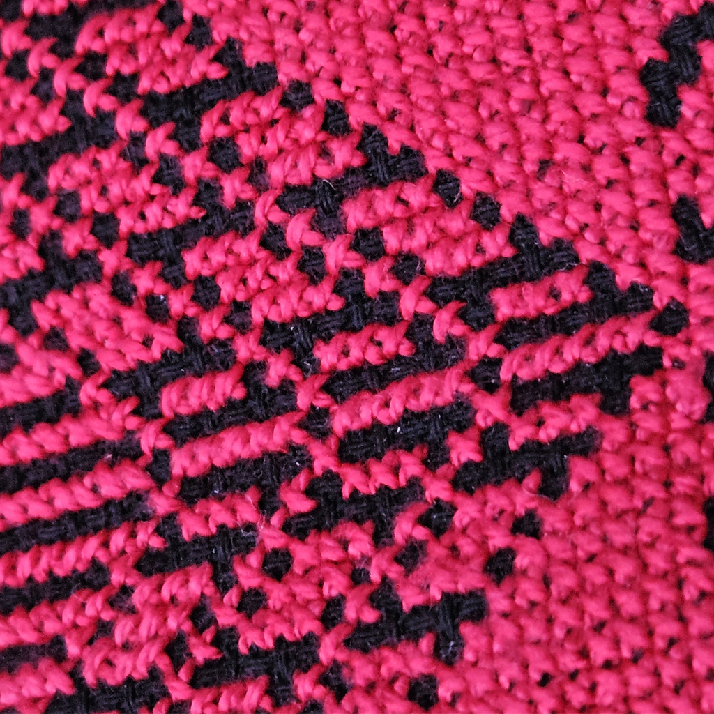 Detailed close-up of the handmade Sabla eyeglasses case, showcasing the red Palestinian Tatreez embroidery against a black fabric background.