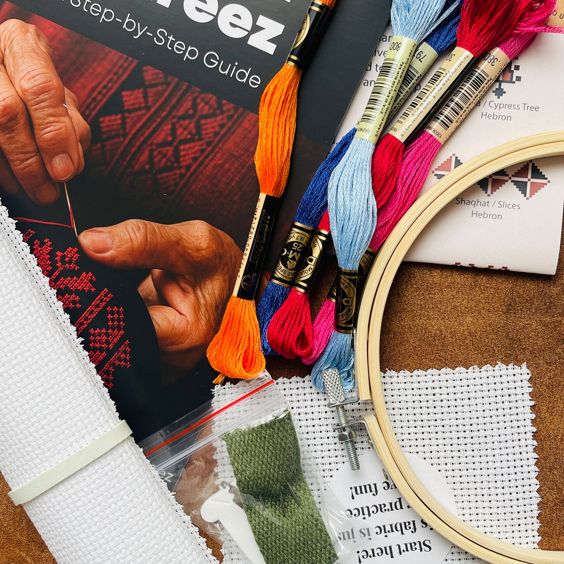 Tatreez embroidery kit contents for Cypress of Gaza pendant including fabric, threads, needle, hoop, and pattern guide