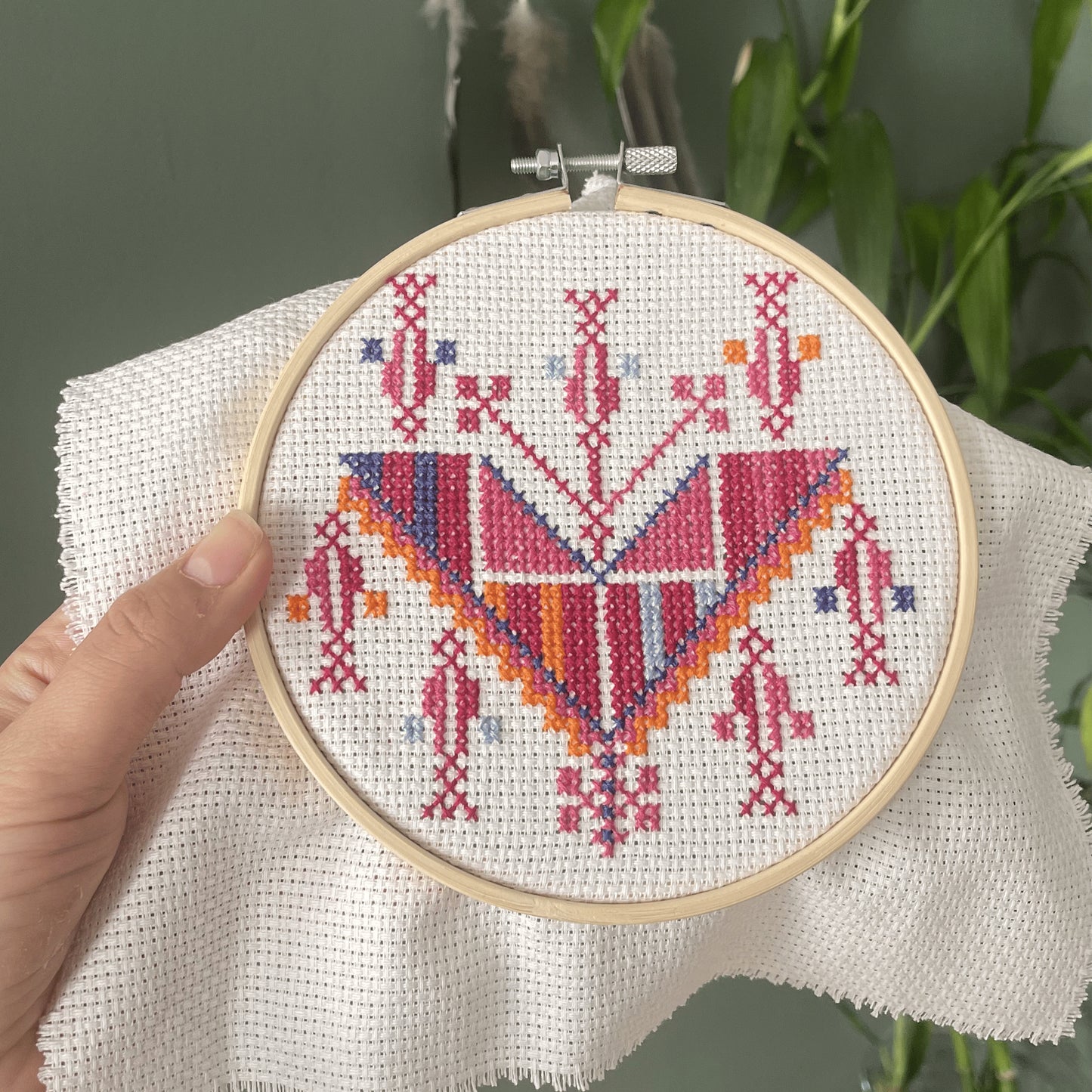 Finished Tatreez embroidery hoop pendant showing Cypress of Gaza pattern in detailed cross stitch
