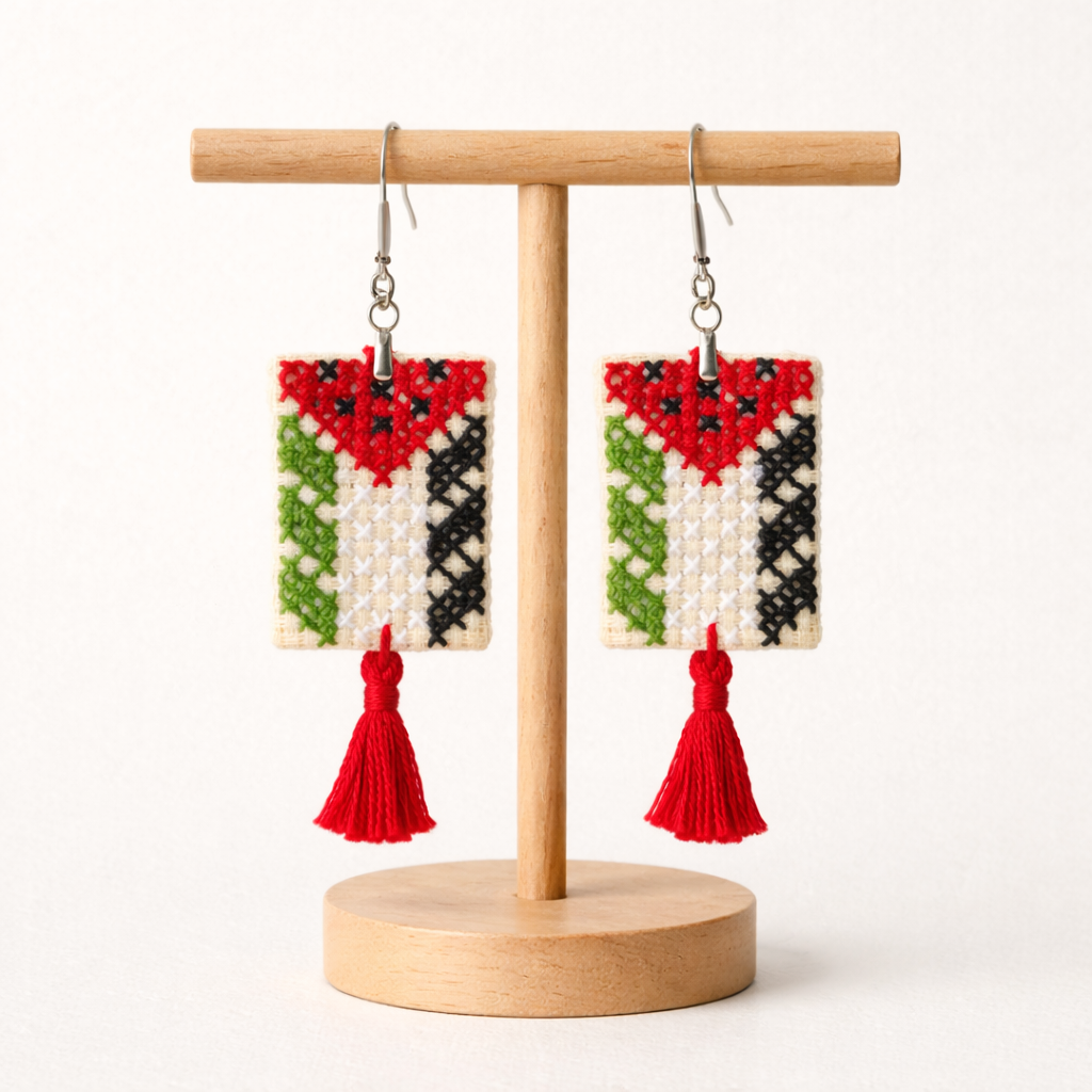 Front view of Palestinian flag Tatreez embroidered earrings with red thread tassel and metal bead on
