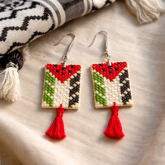 Palestinian flag Tatreez embroidered earrings on textile background with red tassel and metal bead