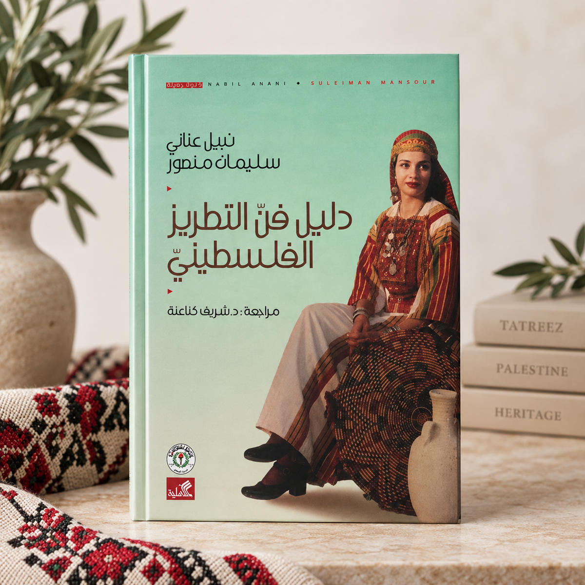 Hardcover edition of The Guide to the Art of Palestinian Tatreez (دليل فن التطريز الفلسطيني) by Nabil Anani and Suleiman Mansour, shown at an angle