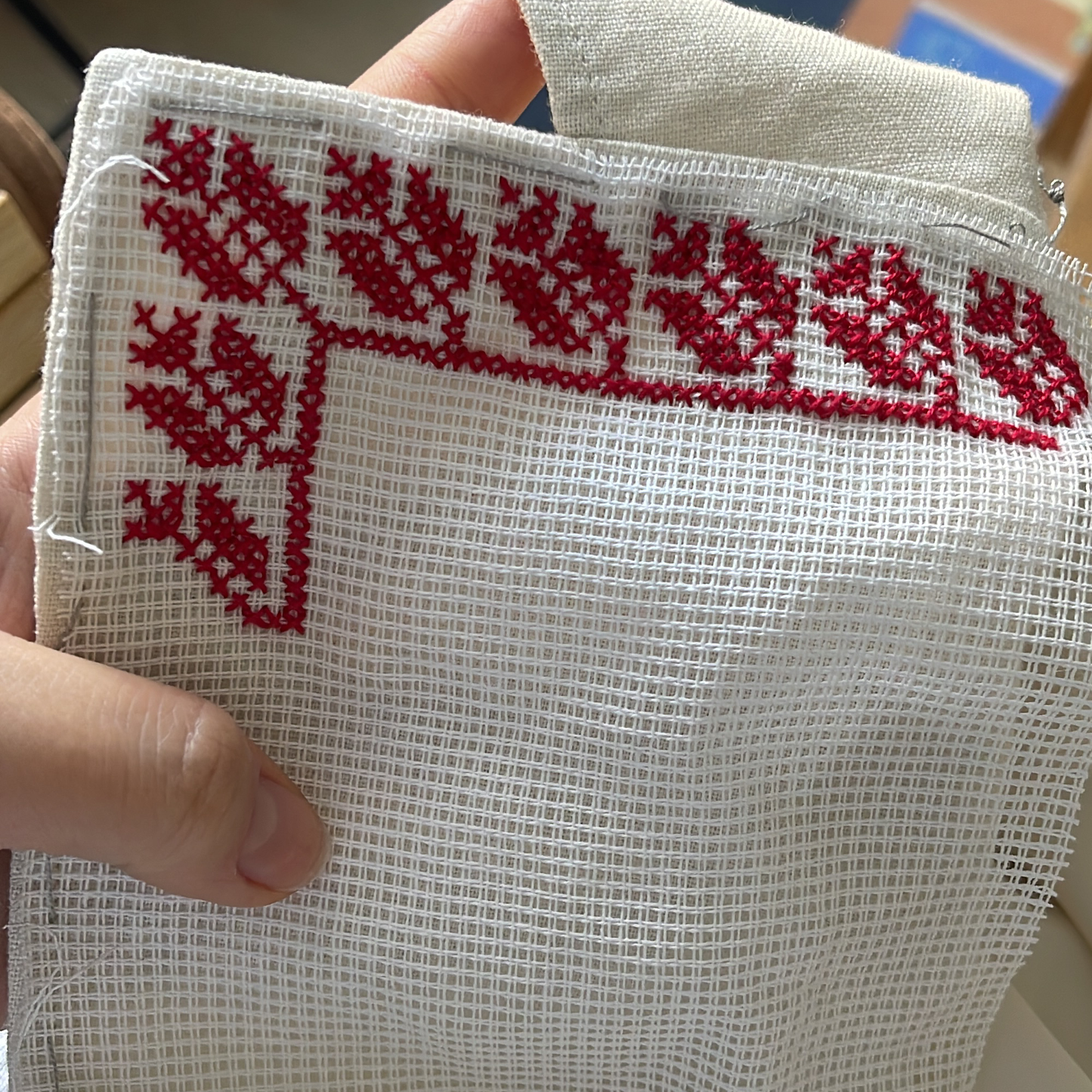 White 14ct waste canvas used as a guide for red tatreez embroidery pattern