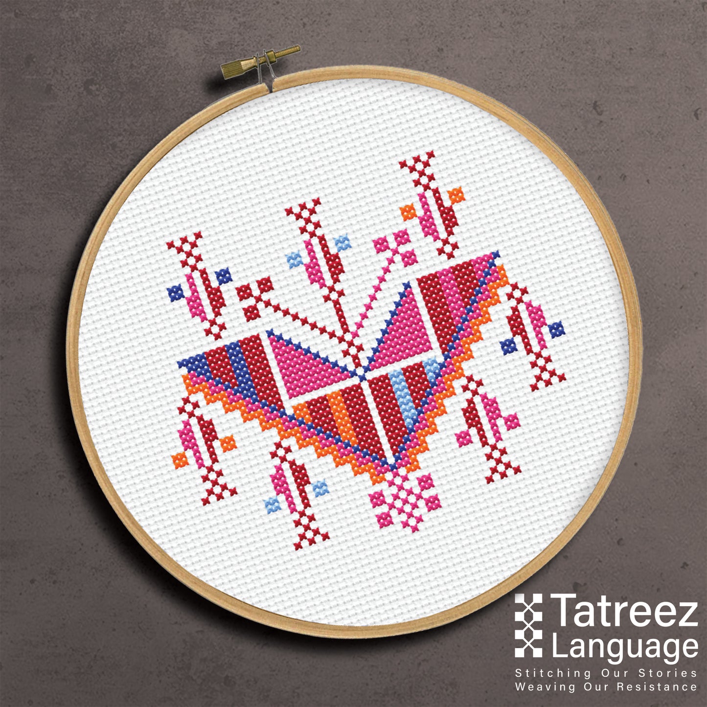 Tatreez embroidery hoop featuring cypress pendant motif from Gaza in red and geometric patterns