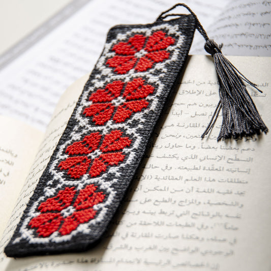 Palestinian tatreez embroidered bookmark placed inside an open book

